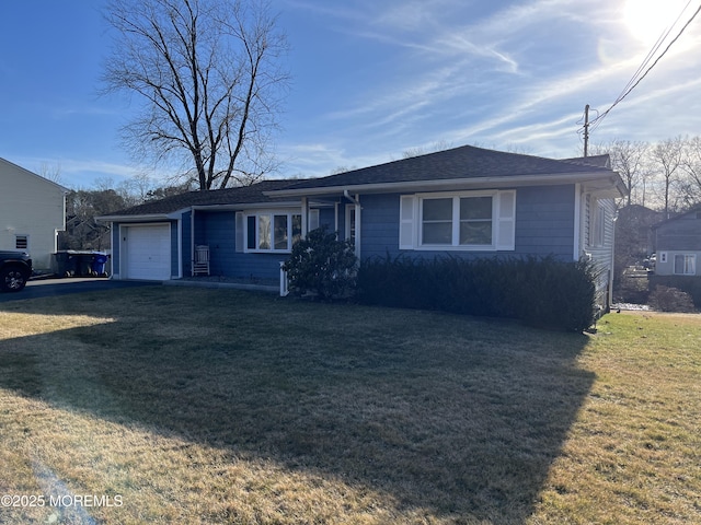 view of front facade with a garage, roof with shingles, and a front yard