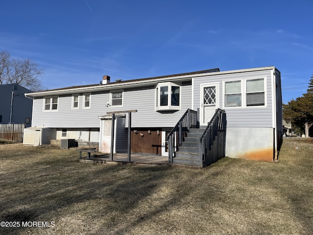 rear view of property with central AC and a yard