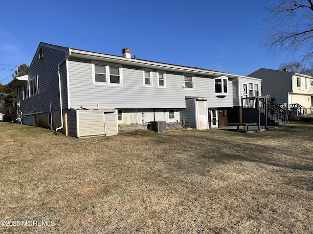 back of house with a chimney, cooling unit, and a yard