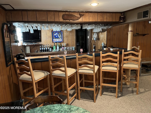 bar with bar area, visible vents, and wooden walls