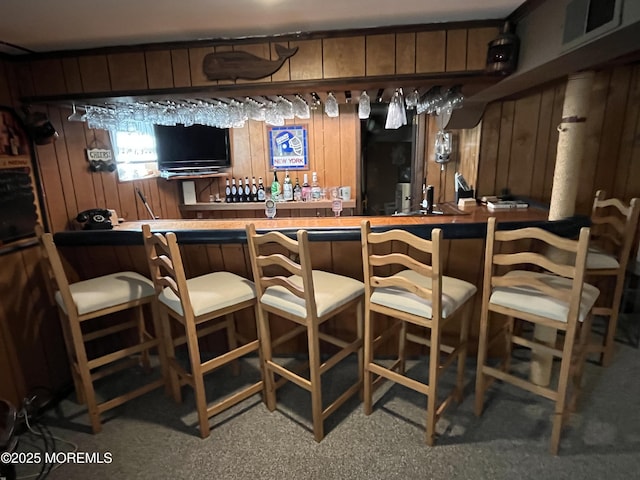 bar featuring a dry bar, visible vents, and wooden walls