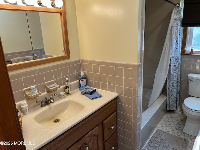 full bathroom with tile walls, shower / bathtub combination with curtain, toilet, wainscoting, and vanity