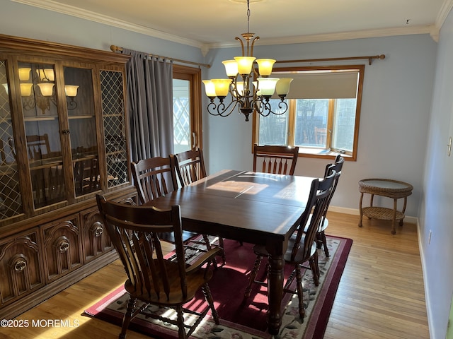 dining room with plenty of natural light, ornamental molding, and light wood-type flooring