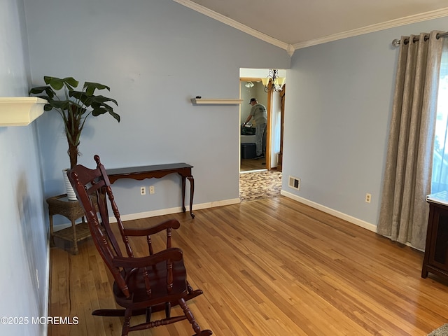 living area featuring light wood finished floors, ornamental molding, visible vents, and baseboards