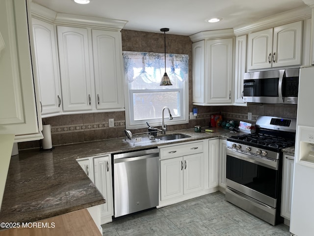 kitchen with tasteful backsplash, white cabinets, dark countertops, stainless steel appliances, and pendant lighting