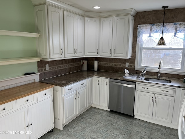 kitchen featuring dishwasher, hanging light fixtures, a sink, and white cabinetry