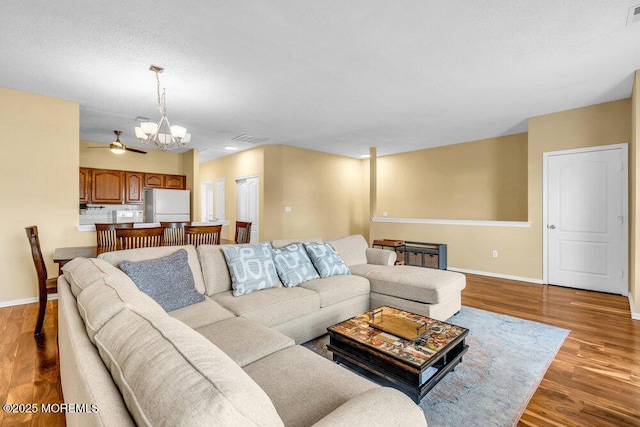 living area featuring baseboards, a notable chandelier, visible vents, and light wood finished floors