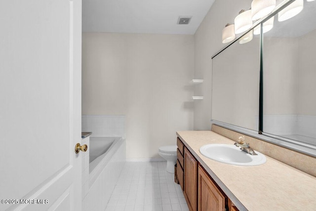 bathroom with a garden tub, toilet, vanity, visible vents, and tile patterned floors