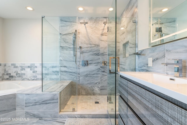 full bathroom featuring recessed lighting, a shower stall, vanity, and a bath