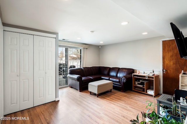 living area featuring light wood-style flooring and recessed lighting