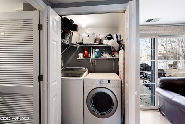 laundry room featuring laundry area, visible vents, independent washer and dryer, and wood finished floors