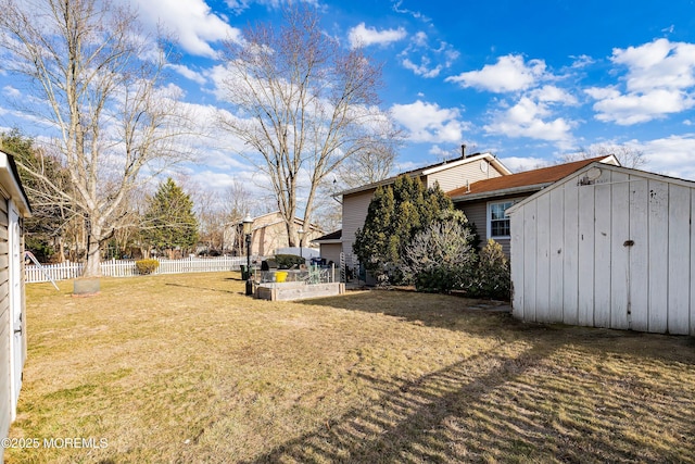 view of yard featuring an outbuilding, a shed, a fenced backyard, and a garden