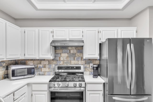 kitchen with stainless steel appliances, white cabinets, light countertops, decorative backsplash, and wall chimney exhaust hood