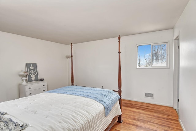 bedroom featuring light wood-type flooring, visible vents, and baseboards