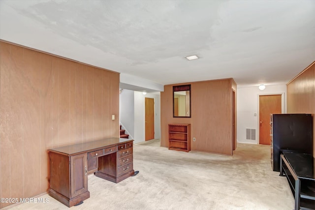 home office featuring visible vents, light colored carpet, and wooden walls