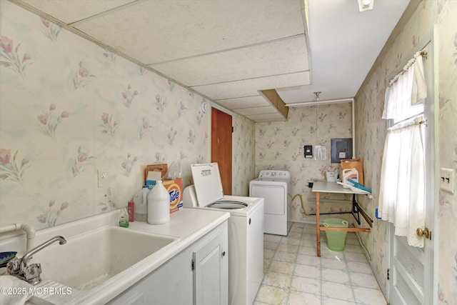 washroom with electric panel, washing machine and dryer, wallpapered walls, and a sink