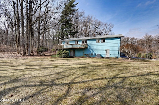 back of house featuring a lawn, a chimney, and a wooden deck