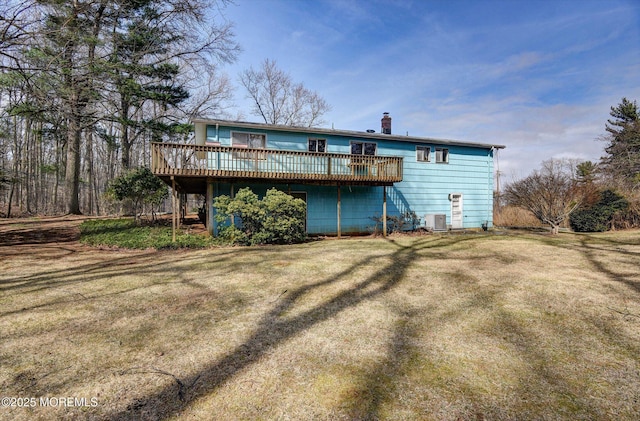 back of house featuring a wooden deck, a yard, and a chimney