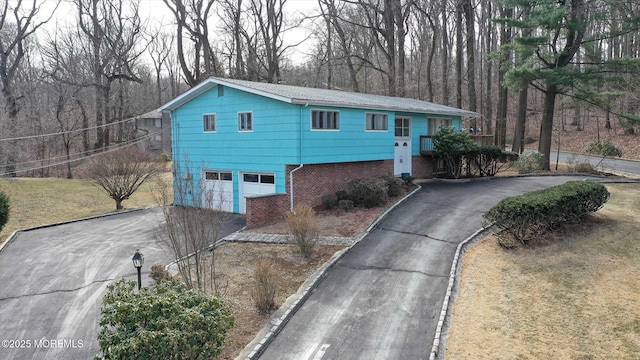 view of front facade featuring brick siding, driveway, and a garage