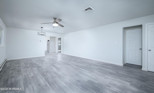 empty room with a ceiling fan, visible vents, baseboards, and wood finished floors