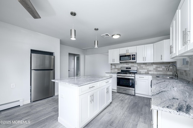 kitchen featuring visible vents, appliances with stainless steel finishes, light wood-style flooring, and a sink