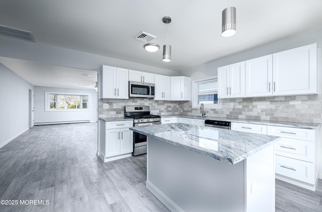 kitchen featuring white cabinets, stainless steel appliances, visible vents, and light stone countertops