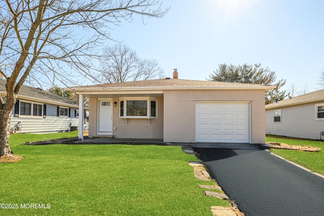 view of front facade with aphalt driveway, a front yard, brick siding, and a chimney