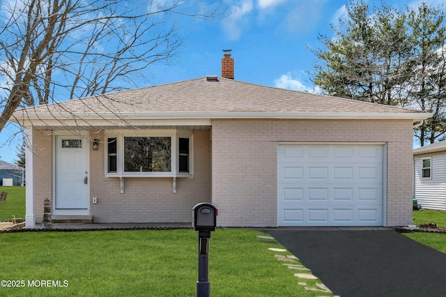 ranch-style house with a chimney, roof with shingles, an attached garage, a front yard, and brick siding