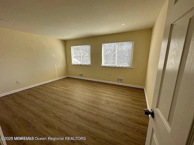 unfurnished bedroom with baseboards, visible vents, and wood finished floors