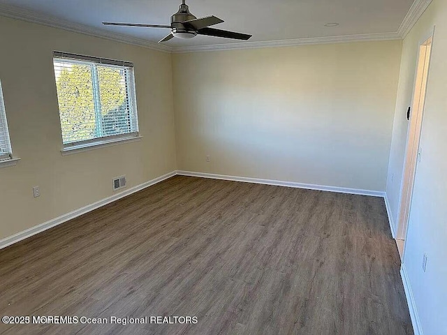 unfurnished room with dark wood-style floors, visible vents, ornamental molding, a ceiling fan, and baseboards