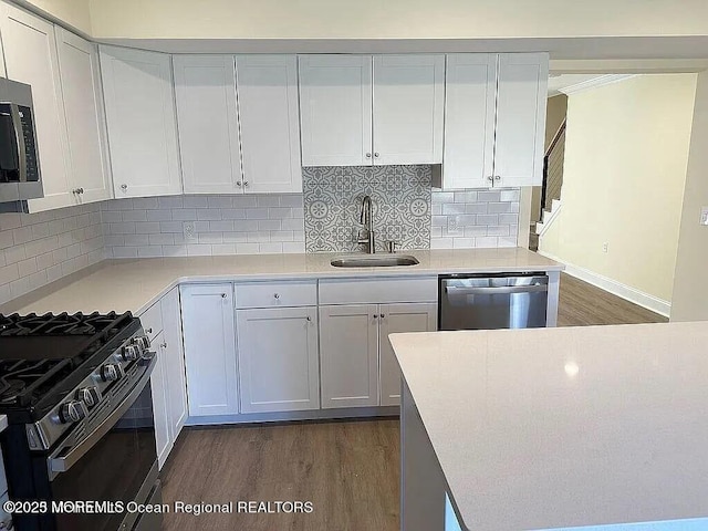 kitchen featuring stainless steel appliances, light countertops, and white cabinetry