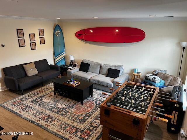 living area with ornamental molding and wood finished floors