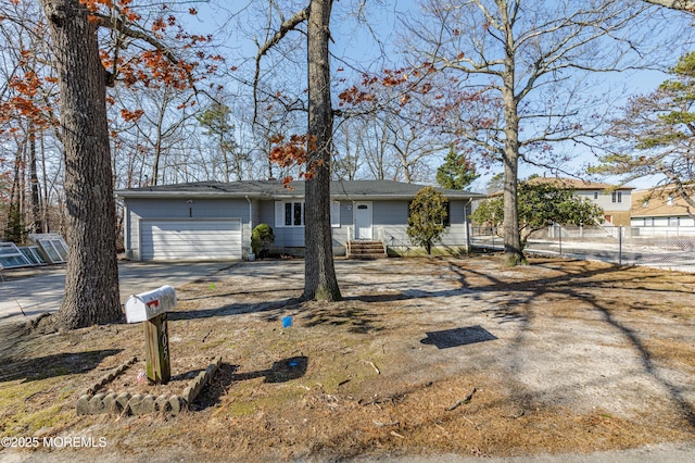 ranch-style house with entry steps, an attached garage, driveway, and fence