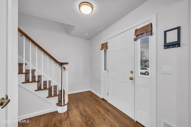 entryway featuring visible vents, stairway, baseboards, and wood finished floors