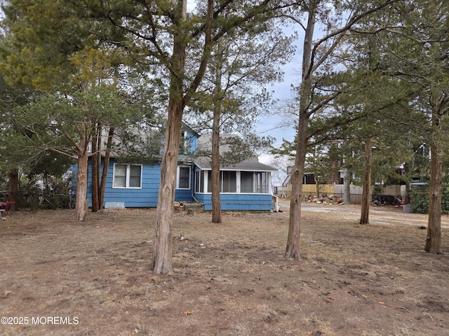 view of front of house featuring a sunroom and fence