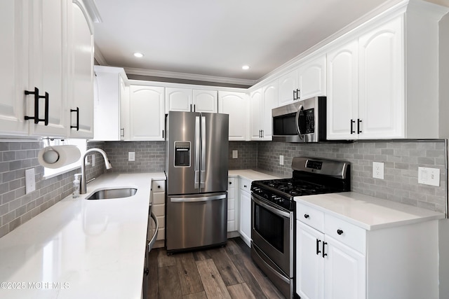 kitchen with a sink, stainless steel appliances, light countertops, and white cabinets