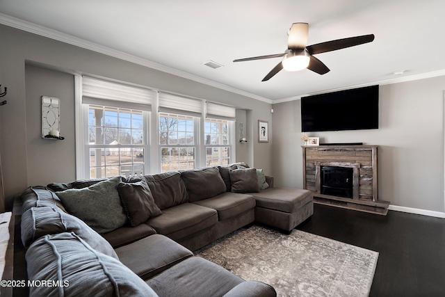 living area with baseboards, dark wood finished floors, visible vents, and crown molding