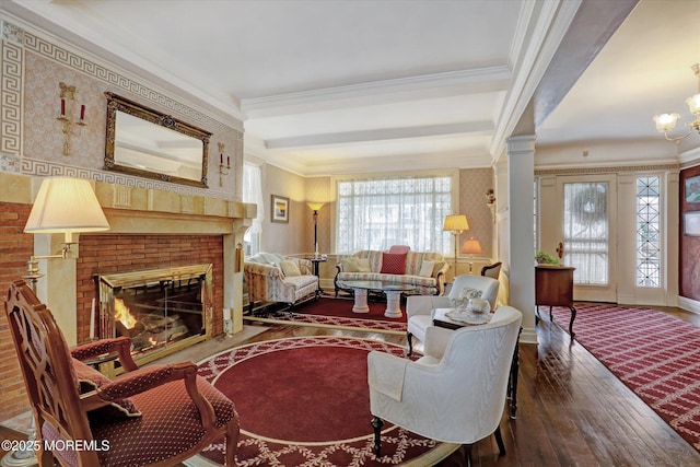 living area featuring ornamental molding, wood-type flooring, a fireplace, and beam ceiling