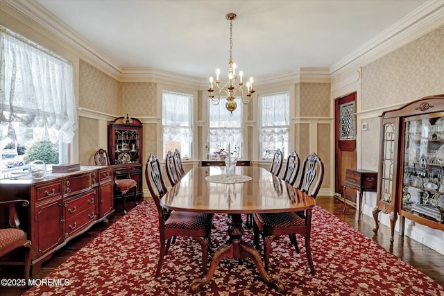 dining room featuring dark wood finished floors, wainscoting, a notable chandelier, and wallpapered walls