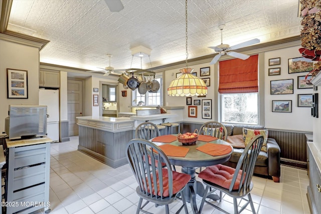 dining area with light tile patterned floors, an ornate ceiling, a ceiling fan, and crown molding