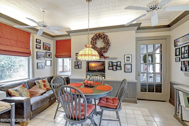 dining space with light tile patterned floors, a ceiling fan, and crown molding