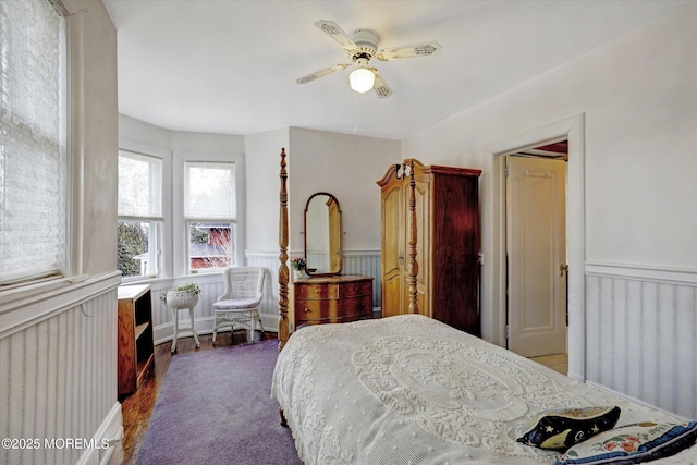 bedroom featuring a wainscoted wall, ceiling fan, and radiator