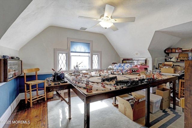 interior space with vaulted ceiling, wood finished floors, visible vents, and baseboards