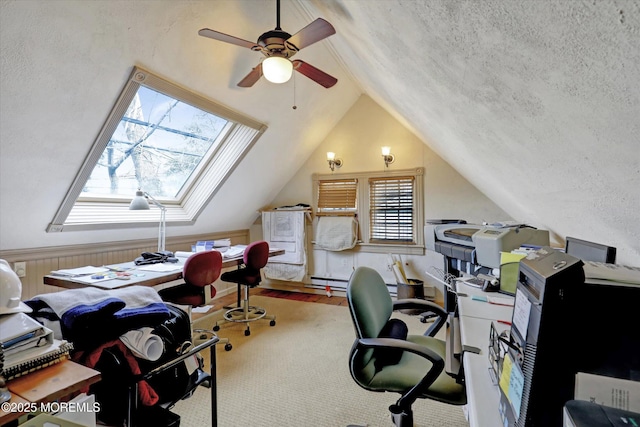 office area featuring vaulted ceiling with skylight, a baseboard heating unit, ceiling fan, and a textured ceiling