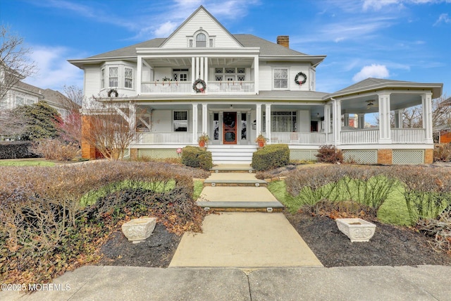 view of front of property with a balcony, a chimney, a porch, and roof with shingles