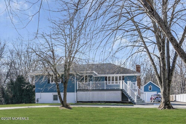 view of front facade with a front yard, a chimney, and stairway