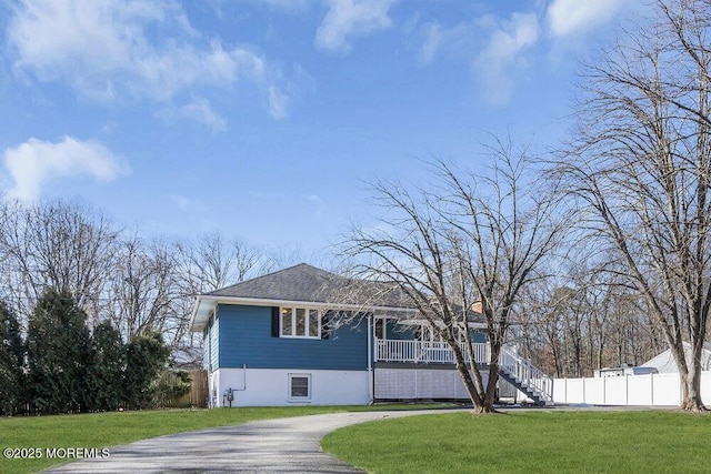 view of front of property with covered porch, stairs, fence, and a front yard