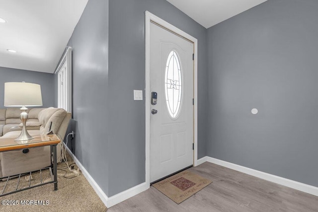 foyer with baseboards and wood finished floors