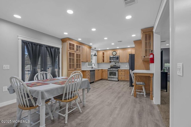 dining area featuring light wood-type flooring, baseboards, visible vents, and recessed lighting