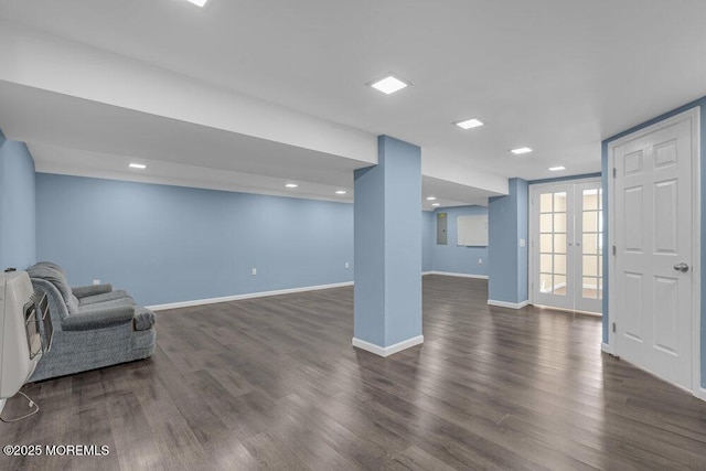 basement featuring baseboards, dark wood-style flooring, and french doors